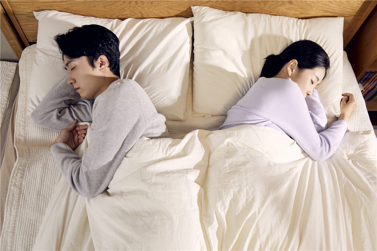 침대에서 서로 등을 돌리고 누운 부부